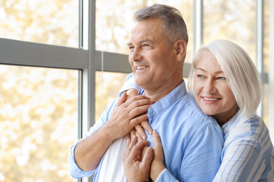 A senior couple at home, looking ahead with confidence